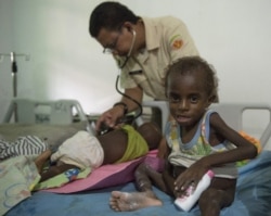 Anggota Satgas TNI memeriksa anak di rumah sakit setempat di Agats, Ibu Kota Kabupaten Asmat pada 26 Januari 2018.(Foto: AFP/Bay Ismoyo)