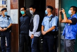 Leung Kam-wai, salah satu anggota Aliansi Hong Kong yang ditangkap dalam aksi mendukung gerakan Demokratik Patriotik China dikawal oleh polisi saat mereka meninggalkan Museum 4 Juni, saat memperingati penumpasan Lapangan Tiananmen 1989, di Hong Kong. (REUTERS)