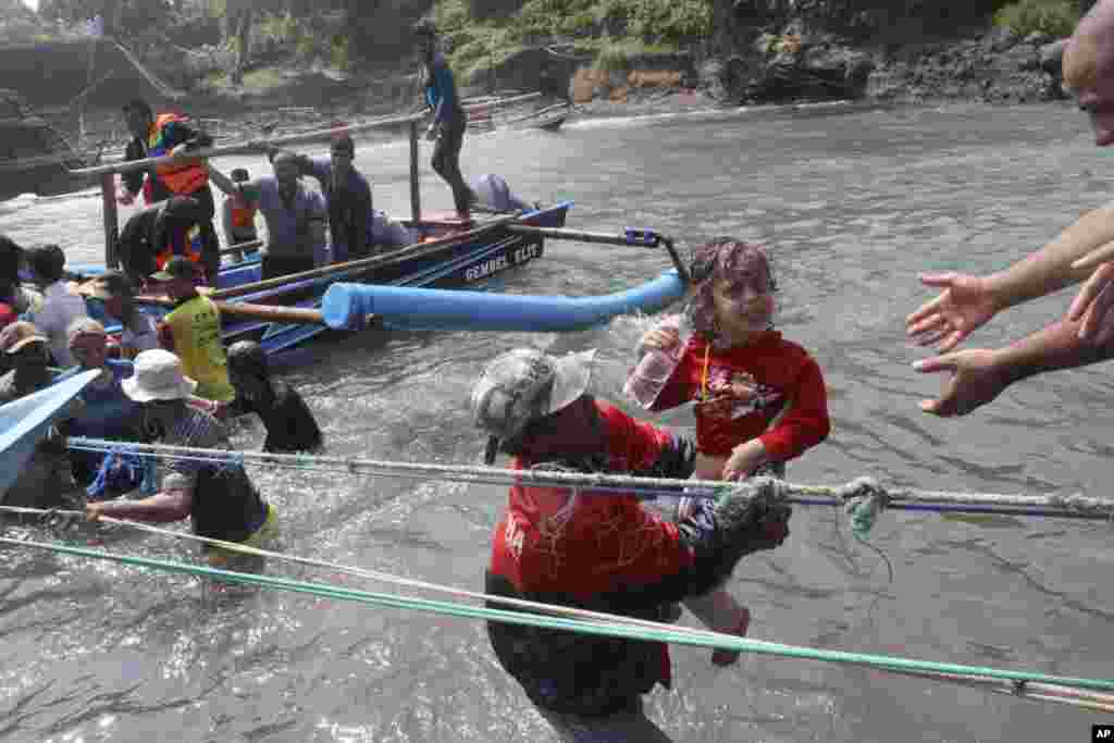 A rescuer carries a child after a boat carrying asylum seekers sank off West Java, Indonesia, July 24, 2013. 