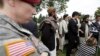 A U.S. soldier looks on as Afghan villagers, some of whom testified earlier in the week, speak through an interpreter with reporters, following a sentencing hearing for Staff Sgt. Robert Bales at Joint Base Lewis-McChord, Washington, Aug. 23, 2013.