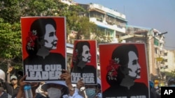 Anti-coup protesters display pictures of deposed Myanmar leader Aung San Suu Kyi in Yangon, Myanmar, Tuesday, March 2, 2021. Police in Myanmar repeatedly used tear gas and rubber bullets Tuesday against crowds protesting last month's coup, but the…