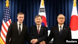 제이크 설리번(왼쪽) 미 백악관 국가안보보좌관과 조태용(가운데) 한국 국가안보실장, 아키바 다케오(오른쪽) 일본 국가안전보장국장이 9일 서울 용산 한국 대통령실 청사에서 공동 브리핑 후 손을 맞잡고 있다. 
