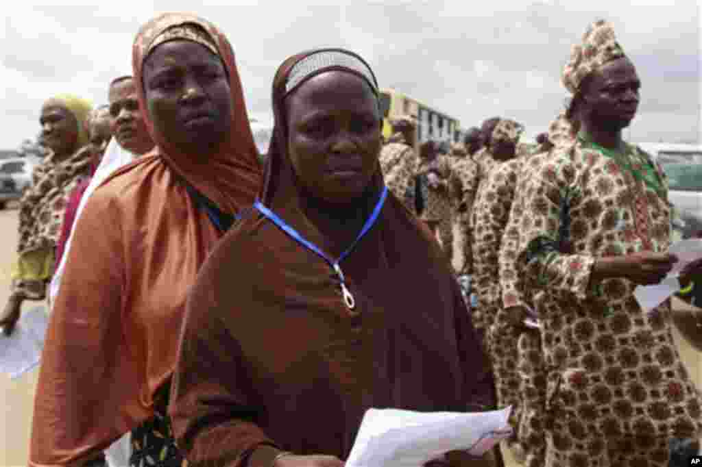 Mahajjata na tsaye a wani sansanin alhazai su na jira a yi mu su gwajin cutar Ebola kafin su shiga jirgin saman zuwa Saudiyya, a ranar goma sha takwas ga watan satumba shekarar dubu biyu da goma sha hudu.