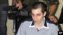 FILE - A Hamas cameraman stands behind Israeli soldier Gilad Schalit, released after more than five years in captivity, on the Egyptian side of the Rafah border crossing on Oct. 18, 2011.