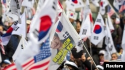 Pendukung mantan presiden Korea Selatan Park Geun-hye berunjuk rasa di depan sebuah pengadilan setelah jaksa menjatuhkan hukuman penjara 30 tahun untuk presiden yang digulingkan tersebut di Seoul, Korea Selatan, 27 Februari 2018. (Foto: dok).