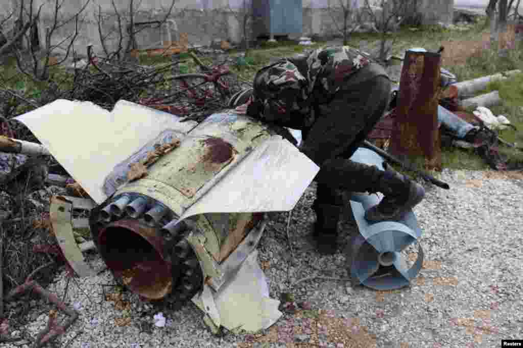A Free Syrian Army fighter inspects war material in Jabal al-Akrad area in Syria's northwestern Latakia province, Jan. 19, 2014.