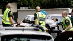 Para petugas ambulans membawa keluar seorang pria dari sebuah masjid di pusat Kota Christchurch, Selandia Baru, 15 Maret 2019. 