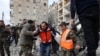 Tim penyelamat tampak membawa jenazah korban gempa dari reruntuhan bangunan yang ambruk dalam proses evakuasi di Aleppo, Suriah, pada 7 Februari 2023. (Foto: AP/Omar Sanadiki)