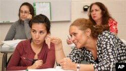 Maria Rguez, of Mexico, learns math skills from volunteer teacher, Dharma Diaz-Azcuy, in a GED preparation class at Marist School, in Atlanta, Georgia, Oct. 11, 2012.