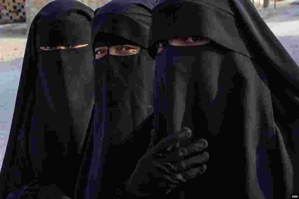 Three women from Iraq keep their niqabs inside al-Hol Camp, the largest detention center for people accused of being part of IS in Northeast Syria, on Oct. 12, 2024. (Diego Baravelli/VOA)