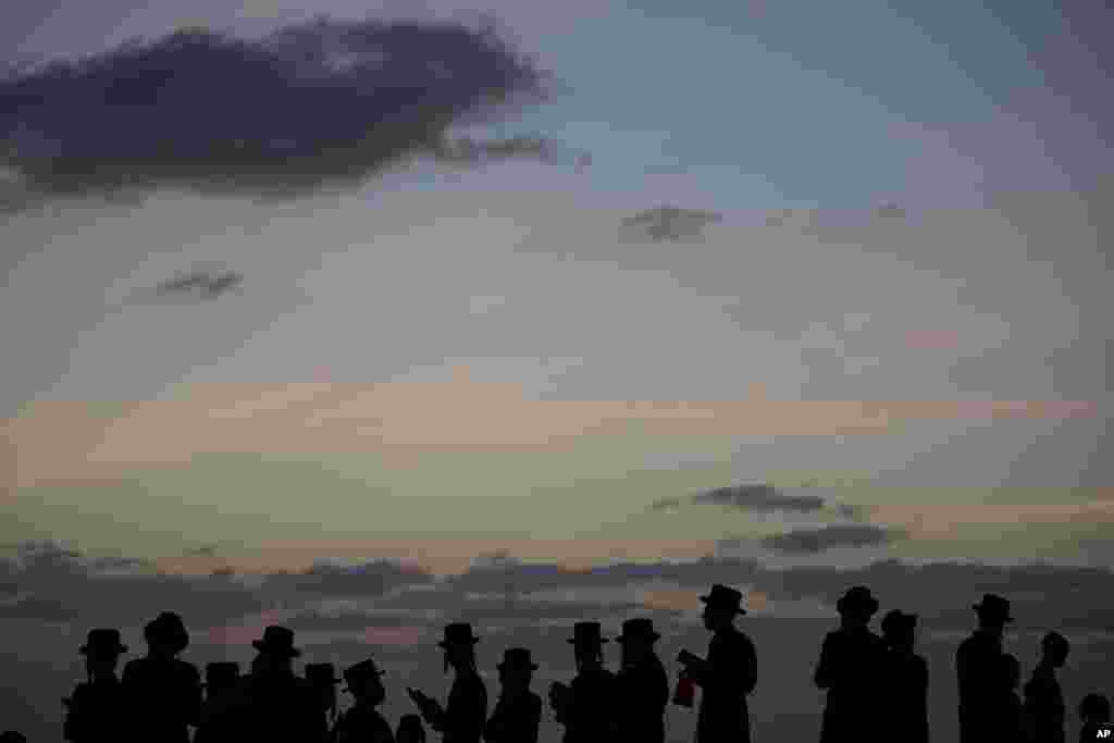 Ultra-Orthodox Jewish men of the Vizhnitz Hassidic sect pray on a hill overlooking the Mediterranean Sea as they participate in a Tashlich ceremony in Herzeliya, Israel.