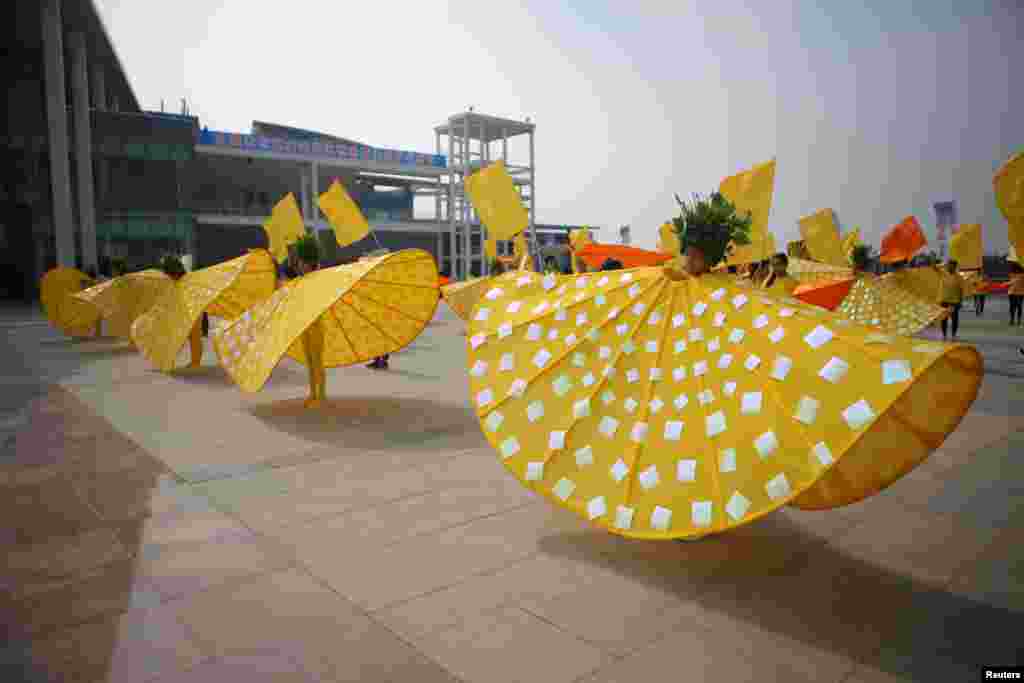 Participants wearing special costumes imitate the flow of the Yellow River during a Yellow River-themed performance in Binzhou, Shandong province, China, Sept. 27, 2016.