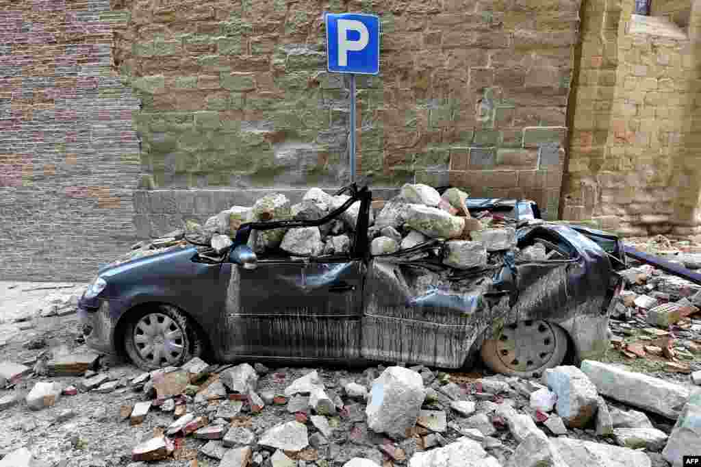 A damaged car in the "red zone", an area cordoned off for safety reasons, in Camerino, where 80 per cent of the houses have been left uninhabitable after two earthquakes hit the region. 