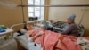 Seorang kenalan menjenguk Marina Klimenko (28), dan Lyudmila Antonenko (46) di rumah sakit di Donetsk, Ukraina yang dikuasai Rusia, 22 Januari 2024. Keduanya terluka akibat serangan militer Ukraina. (REUTERS/Alexander)