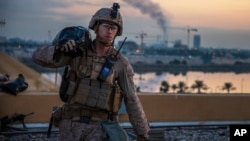 Seorang marinir AS sedang memanggul karung pasir untuk membentengi kompleks Kedutaan Besar AS di Baghdad, Irak, 4 Januari 2020. (Foto: Sersan Kyle C. Talbot, Korps Marinir AS via AP)