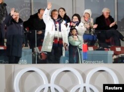 9일 강원도 평창에서 열린 2018 평창동계올림픽 개막식에서 문재인 한국 대통령(가운데), 토마스 바흐 IOC 위원장(왼쪽)이 관중을 향해 손을 흔들고 있다. 그 뒤로 김영남 북한 최고인민회의 상임위원장(뒷줄 두번째)과 김정은 북한 국무위원장의 여동생인 김여정 노동당 중앙위 제1부부장(뒷줄 세번째) 모습이 보인다.