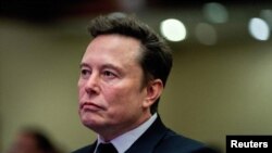 FILE - Tesla CEO and X owner Elon Musk listens as US President-elect Donald Trump speaks during a meeting with House Republicans at the Hyatt Regency hotel in Washington, on November 13, 2024. 