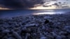 FILE - Dried coral lies on a beach as the sun sets on Lady Elliot Island, 80 kilometers northeast of Bundaberg in Queensland, Australia, June 10, 2015.