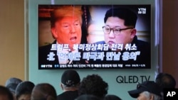Televisi di stasiun kereta Seoul, Korsel, menayangkan berita tentang presiden AS Donald Trump (kiri) dan Pemimpin Korea Selatan Kim Jong-un, 25 Mei 2018. 