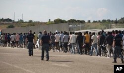 Arhiva - Italijanska granična policija sprovodi migrante iz podsaharskih zemalja u centar za relokaciju, nakon što su stigli spasilačkim brodom u Augustu, na Siciliji, Italija, 23. juna 2017.