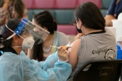 Para pelajar AS usia belasan tahun menerima vaksinasi COVID-19 di sebuah SMP di Los Angeles, California (foto: dok).