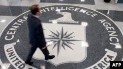 FILE - A man crosses the Central Intelligence Agency logo in the lobby of CIA Headquarters in Langley, Virginia.