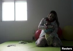 Physiotherapist Jeime Lara Leal does exercises with Lucas, 4-months old, who is Miriam Araujo's second child and born with microcephaly in Pedro I hospital in Campina Grande, Brazil, Feb. 17, 2016.