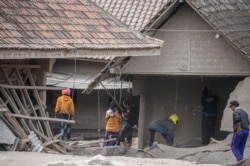 Petugas penyelamat melakukan pencarian warga di daerah yang tertutup abu vulkanik di Desa Sumber Wuluh di Lumajang pada 5 Desember 2021, setelah letusan Gunung Semeru yang menewaskan sedikitnya 13 orang. (Foto: AFP/Juni Kriswanto)