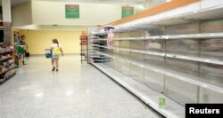 Kupci prolaze pored praznih rafova, koji su inače puni flašama i balonima vode, u supermarketu pred dolazak uragana Irma u Kisimi, Florida, 9. septembra 2017.