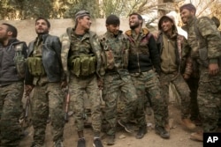 U.S.-backed Syrian Democratic Forces fighters celebrate their territorial gains over Islamic State militants in Baghuz, Syria, March 19, 2019.