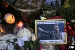 A photograph of British singer George Michael is seen among floral tributes and candles outside Michael's north London home on Dec. 26, 2016, after news of the singer's death broke.