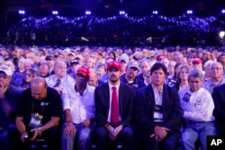 Audience members listen as President Donald Trump speaks at the National Rifle Association Leadership Forum, April 28, 2017, in Atlanta.