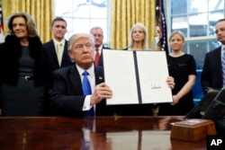 Presiden Donald Trump dan keputusan larangan imigran yang ditandatanganinya di Oval Office, Gedung Putih, 28 Januari 2017.