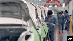 แฟ้ม - คนงานประกอบรถยนต์ ของบริษัท Geely ในประเทศจีน 21 มิ.ย. 2012 (AP Photo/Eugene Hoshiko)