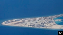 FILE - an airstrip, structures and buildings on China's man-made Subi Reef in the Spratly chain of islands in the South China Sea are seen from a Philippine Air Force C-130 transport plane of the Philippine Air Force.