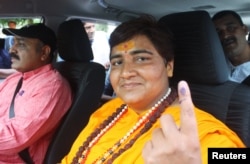FILE - Pragya Singh Thakur, leader of ruling Bharatiya Janata Party (BJP), shows her ink-marked finger after casting her vote, outside a polling station in Bhopal, India, May 12, 2019.