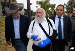 Rabbi Yisroel Goldstein, center, arrives for a news conference at the Chabad of Poway synagogue, April 28, 2019, in Poway, California.
