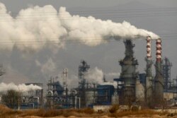 FILE - Smoke and steam rise from a coal processing plant in Hejin in central China's Shanxi Province, Nov. 28, 2019.