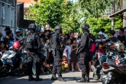 Densus 88 mengepung sebuah jalan ketika mereka menggeledah sebuah rumah di Surabaya, Jawa Timur, pada 19 Juni 2017. (Foto: AFP/Juni Kriswanto)