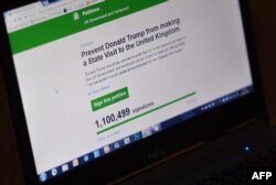 In this posed picture taken in Brenchly, south-east England on January 30, 2017, a laptop screen displays a parliamentary petition on the website of the British government, demanding Britain cancel a planned state visit by U.S. President Donald Trump.