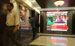 A man offers prayer to a Hindu goddess at the Bombay Stock Exchange (BSE) office, as India's Finance Minister Nirmala Sitharaman is seen on a television screen presenting the annual budget in Mumbai, India, July 5, 2019.