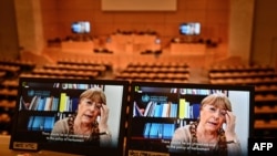 A picture taken on February 25, 2021 shows United Nations High Commissioner for Human Rights Michelle Bachelet on a screen as she speaks on Belarus via video-link during a session of the UN Human Rights Council in Geneva. - The United Nations rights…