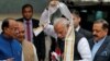 India's Prime Minister Narendra Modi removes a stole given to him by a minister upon his arrival at the Parliament on the first day of the winter session in New Delhi, India, Dec. 11, 2018. 