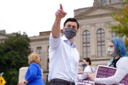 FILE - Democratic candidate for Senate Jon Ossoff points after a news conference in Atlanta, Georgia, Nov. 10, 2020.