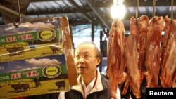 An official from the Taipei City Department of Health inspects a beef stall in a traditional market with reporters in Taipei, March 22, 2012. 