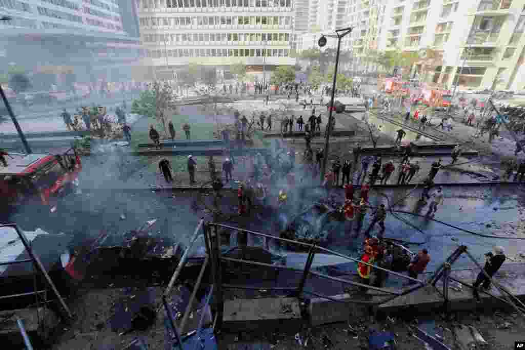 Lebanese firefighters extinguish burned vehicles at the scene of an explosion in Beirut, Lebanon, Dec. 27, 2013.