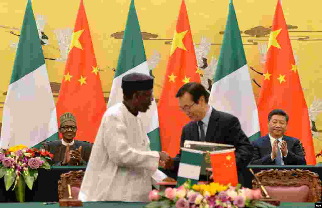 Shugaba Muhammadu Buhari na Najeriya da shugaba Xi Jinping na kasar Sin su na tafawa a yayin da wakilan tawagoginsu suke gaisawa a Babban Dakin Taron Al'umma dake birnin Beijing, talata 12 Afrilu 2016