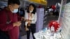 Seorang pengunjung mengenakan masker memperhatikan model virus corona untuk vaksin COVID-19 yang dipamerkan oleh perusahaan farmasi China Sinopharm di China International Fair for Trade in Services (CIFTIS) di Beijing, Sabtu, 5 September 2020.