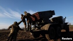 Ukranian service members prerpare to lauch rockets in the Bakhmut region