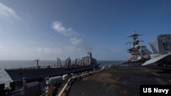 FILE - The USNS Big Horn sails alongside the aircraft carrier USS Abraham Lincoln during a fueling-at-sea on Sept. 5, 2024.